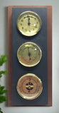 Natural cleft Black slate 3-hole hanging Rangeley weather station on a mahogany background with clock, thermometer, and barometer with gold faces
